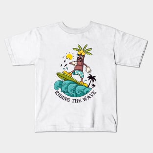 Riding the Wave, a coconut tree cartoon mascot who surfs the waves Kids T-Shirt